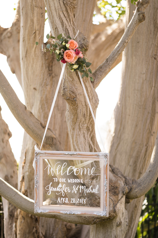 wedding welcome sign hanging in tree