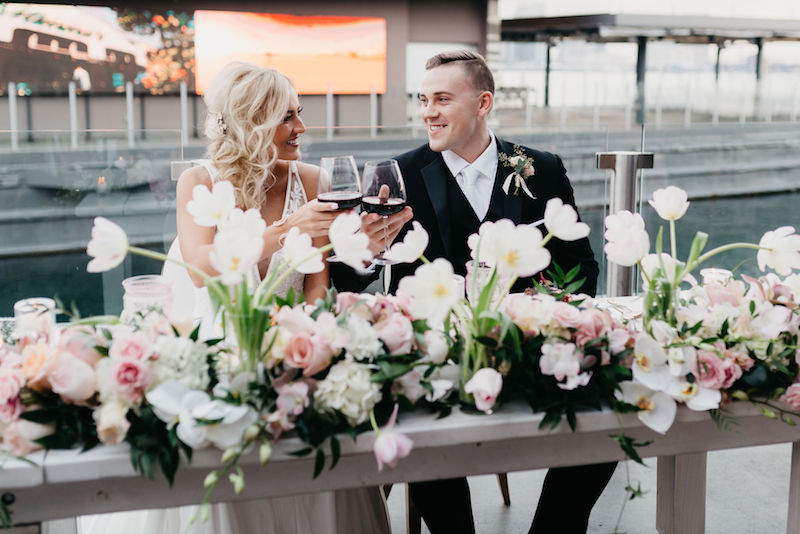 sweetheart table, bride and groom, wine glasses, toasting