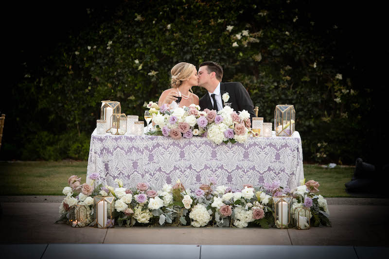 bride and groom, sweetheart table, kiss, flowers