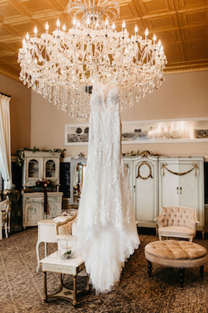 wedding dress hanging from chandelier